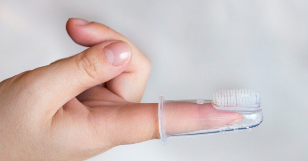 primary teeth care with a over-the-finger toothbrush