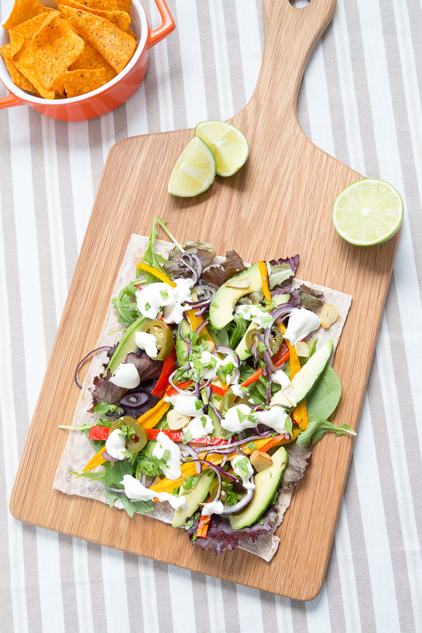 Open vegetarian wrap - roasted peppers, red onions and garlic with mixed leaves, avocado, sour cream, jalapeños, lime juice and freshly chopped coriander. Served with nacho style crisps.