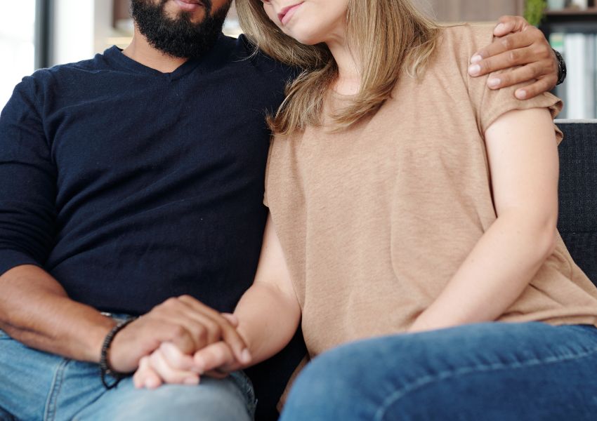 Couple holding hands, symbolizing emotional support after miscarriage.